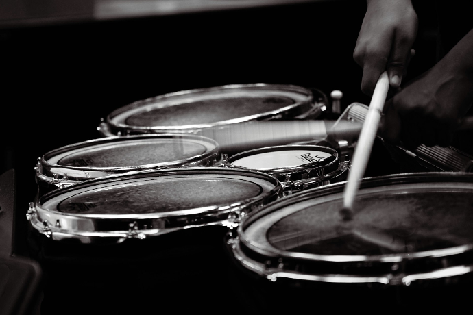 A person is playing drums in a black and white photo